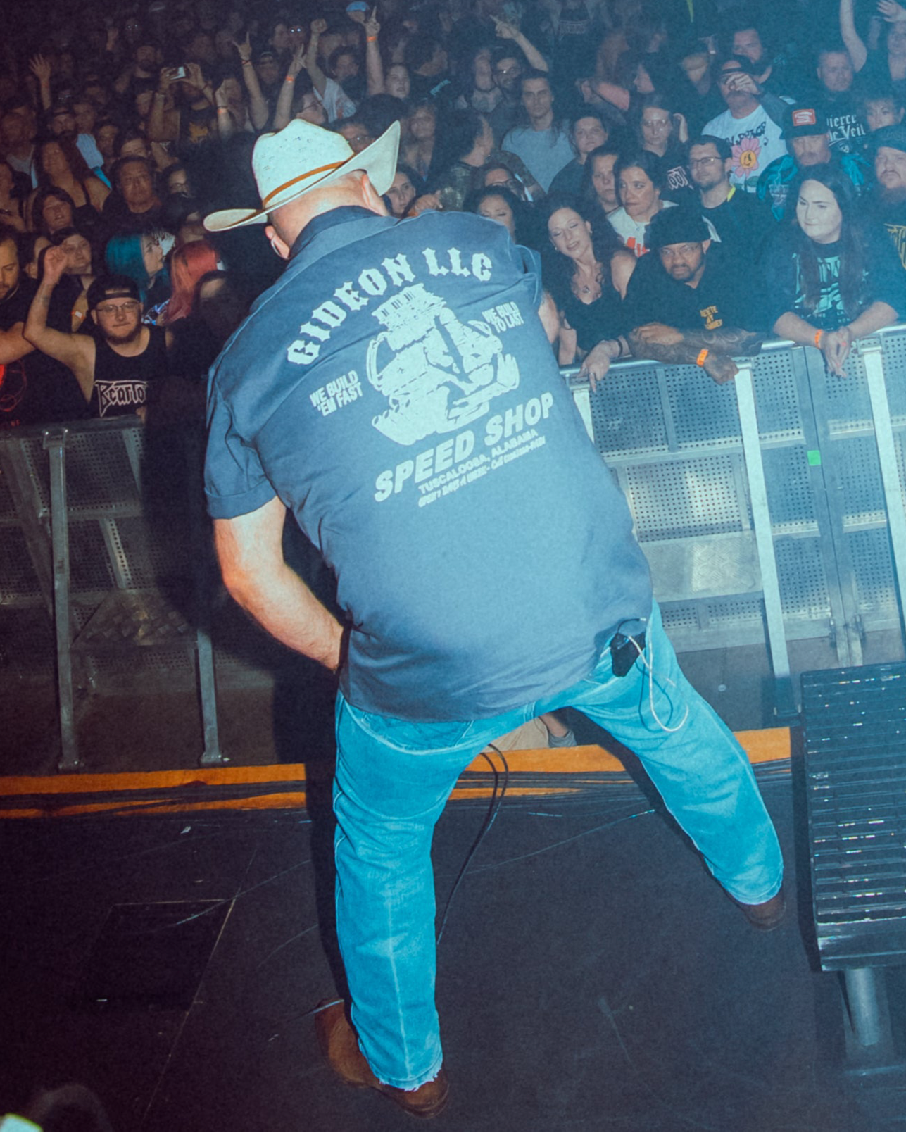 Daniel McWhorter the vocalist of Gideon on stage wearing Speed Shop Mechanic Shirt. Printed on Dickies. We build em fast, we build to last and an engine image.