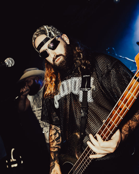 GIDEON BASSIST CALEB DERUSHA ON STAGE WEARING SCRIMMAGE JERSEY