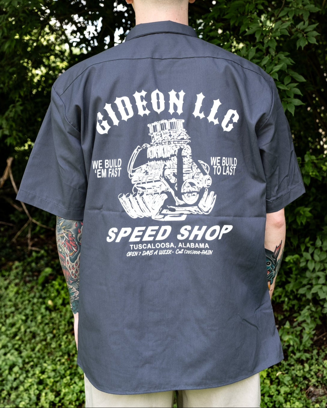 BACK PRINT OF GIDEON LLC SPEED SHOP "WE BUILD EM FAST. WE BUILD TO LAST" WHITE PRINT ON CHARCOAL/GREY DICKIES BUTTON UP COLLARED WORK SHIRT.