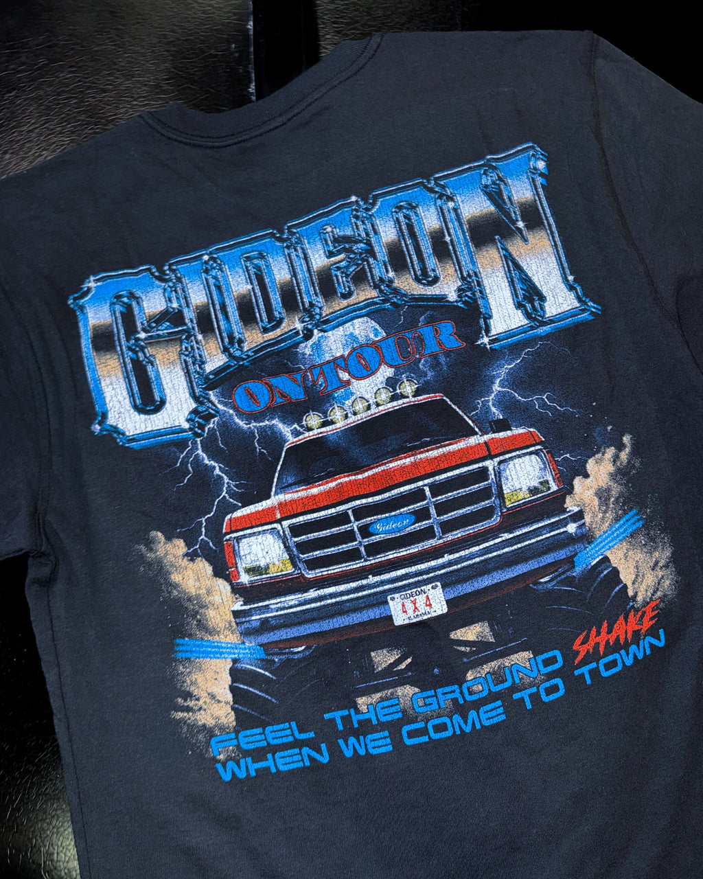 Black t-shirt with a graphic design of a truck and text on a dark background